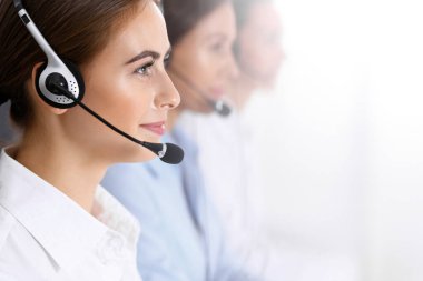 Merkezi ara. Bir grup operatör iş başında. Kulaklık takmış güzel bir iş kadınıyla