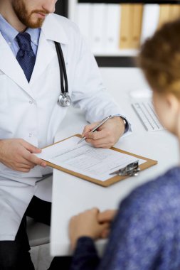 Kadın doktor ve erkek hasta klinikte otururken sağlık muayenesini tartışıyorlar. Tıp konsepti