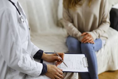 Bilinmeyen kadın doktor ve hasta içeride otururken sağlık muayenesini tartışıyorlar. Coronavirus salgını ve kendini izolasyon karantinası süresince evde kal