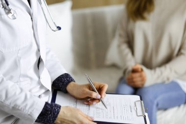 Bilinmeyen kadın doktor ve hasta içeride otururken sağlık muayenesini tartışıyorlar. Coronavirus salgını ve kendini izolasyon karantinası süresince evde kal