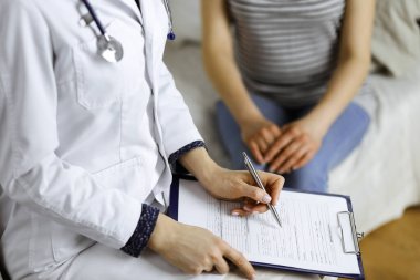 Bilinmeyen kadın doktor ve hasta sıcak oturma odasında otururken sağlık muayenesini tartışıyorlar. Coronavirus salgını ve kendini izolasyon karantinası süresince evde kal