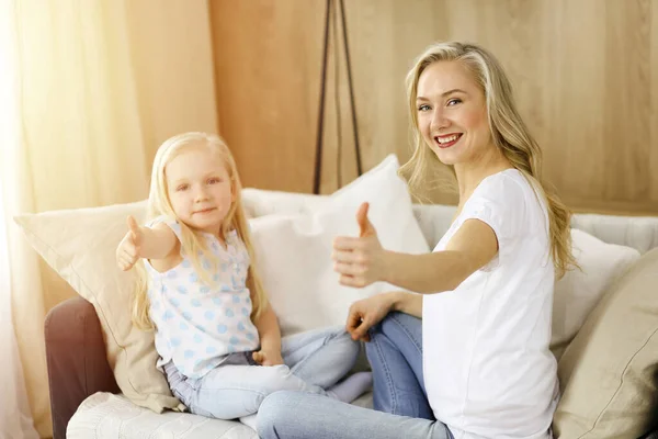 Glückliche Familie in sonniger Wohnung. Blonde junge Mutter beim Spielen und Umarmen mit ihrer süßen Tochter. Mutterschaftskonzept — Stockfoto