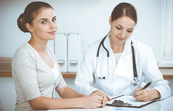 Arzt und Patient sitzen in der Praxis und besprechen die Untersuchungsergebnisse. Gesundheitswesen, Medizin und Konzepte für gute Nachrichten — Stockfoto