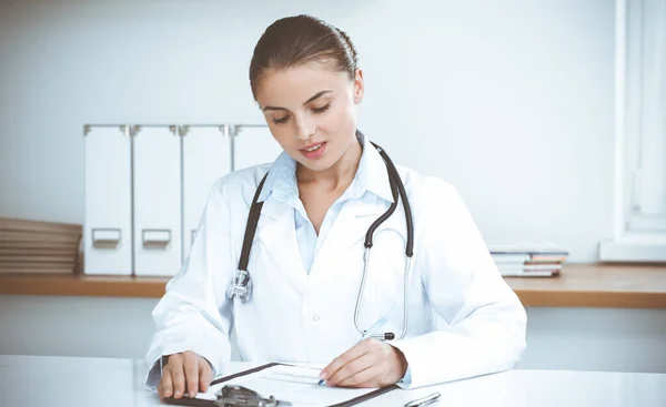 Mulher-médico sentado e trabalhando no consultório da clínica. Retrato de médica. Conceito de medicina — Fotografia de Stock