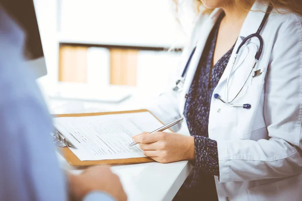 Médica e paciente do sexo masculino discutindo o exame de saúde atual enquanto sentado na clínica, close-up. Conceito de medicina — Fotografia de Stock