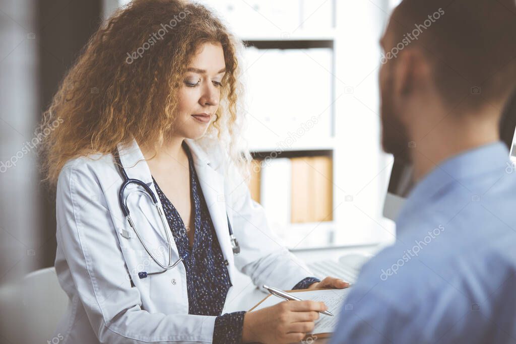 Female doctor and male patient discussing current health examination while sitting in clinic, close-up. Medicine concept