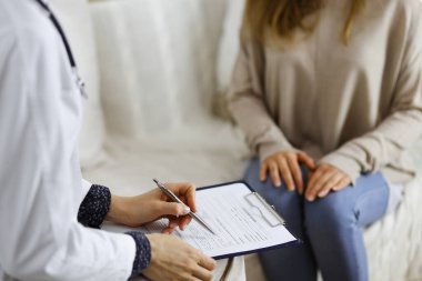 Bilinmeyen kadın doktor ve hasta içeride otururken sağlık muayenesini tartışıyorlar. Coronavirus salgını ve kendini izolasyon karantinası süresince evde kal