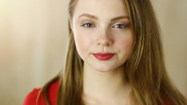 Zeki, kendinden emin, gülümseyen Avrupalı bir kadının resmi. Kollarını kavuşturmuş evde bekliyor.