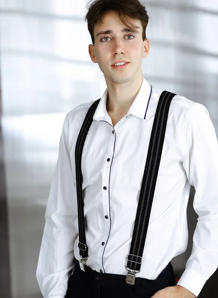 Amical jeune homme d'affaires en chemise blanche est debout dans le bureau moderne — Photo