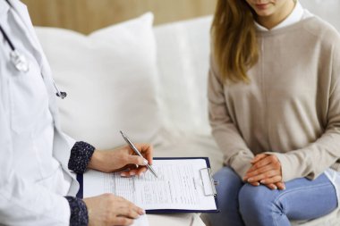 Bilinmeyen kadın doktor ve hasta içeride otururken sağlık muayenesini tartışıyorlar. Coronavirus salgını ve kendini izolasyon karantinası süresince evde kal