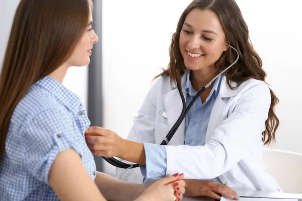 Doutor com um estetoscópio na mão examinando sua paciente feminina. Conceitos de saúde, cardiologia e medicina — Fotografia de Stock