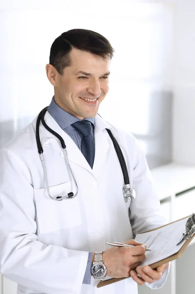 Doctor hombre usando portapapeles para llenar los registros del historial de medicamentos. Servicio médico perfecto en la clínica. Médico trabajando en el hospital. Medicina y conceptos sanitarios — Foto de Stock