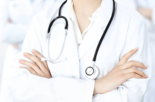 Άγνωστη γυναίκα-γιατρός στέκεται ευθεία με τα χέρια σταυρωμένα στην κλινική, κοντινό πλάνο. Ιατρική ομάδα έτοιμη να σταματήσει την πανδημία του κορωναϊού. Έννοια ιατρικής — Φωτογραφία Αρχείου
