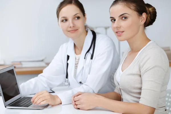 Lekarz i pacjent siedzą i omawiają wyniki badań zdrowotnych podczas korzystania z laptopa. Opieka zdrowotna, medycyna i dobre wiadomości — Zdjęcie stockowe