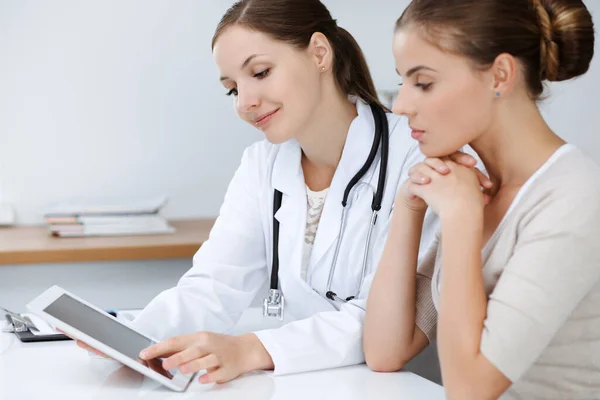 Orvos és a beteg ül, és megvitassák az egészségügyi vizsgálati eredmények használata közben tabletta számítógép. Egészségügy, orvostudomány és jó hírek — Stock Fotó
