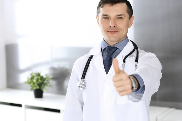 Doutor homem alegre sorrindo para a câmera, polegares para cima. Serviço médico perfeito na clínica. Futuro feliz na medicina e na saúde — Fotografia de Stock