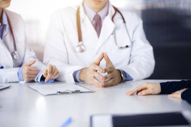 Hasta kadın ve iki doktor modern klinikteki masada otururken bir şey tartışıyorlar. Mükemmel sağlık hizmeti, tıp konsepti