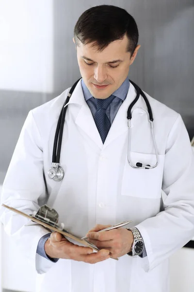 Médico a usar prancheta para encher registos de histórico de medicação. Serviço médico perfeito na clínica. Médico a trabalhar no hospital. Conceitos de medicina e saúde — Fotografia de Stock