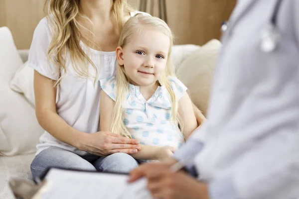 Docteur et patient. Pédiatre utilisant le presse-papiers tout en examinant la petite fille avec sa mère à la maison. Joyeux enfant caucasien mignon à l'examen médical. Concept de médecine — Photo