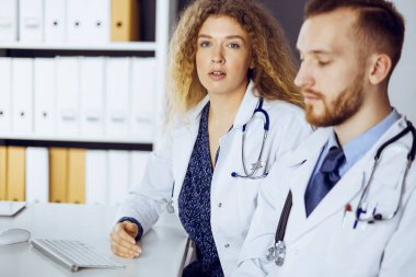 Kızıl sakallı doktor ve bayan meslektaşı klinikte çalışırken güncel hastalık terapisini tartışıyorlar. Tıpta takım çalışması