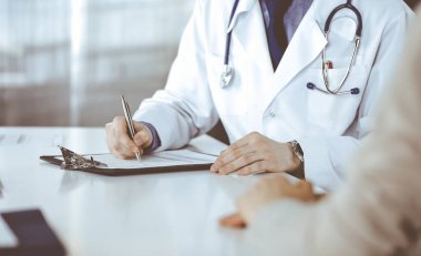 Bilinmeyen erkek doktor ve hasta kadın klinikte oturup dosya kullanırken bir şey tartışıyorlar. Hastanedeki en iyi sağlık hizmeti, ilaç, salgın durdurma.