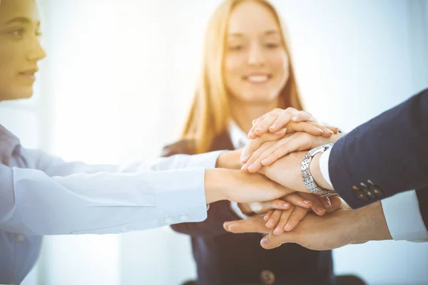 Geschäftsteam zeigt im sonnigen Büro Geschlossenheit mit den Händen. Gruppe von Menschen, die sich die Hände reichen und das Konzept der Freundschaft, Teamarbeit und Partnerschaft repräsentieren — Stockfoto