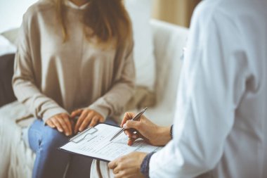 Bilinmeyen kadın doktor ve hasta içeride otururken sağlık muayenesini tartışıyorlar. Coronavirus salgını ve kendini izolasyon karantinası süresince evde kal