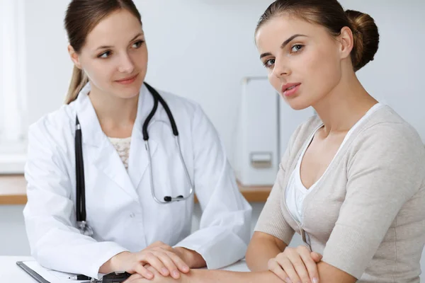 Doctor and patient are sitting and discussing health examination results in clinic office. Health care, medicine and good news concepts — Stock Photo, Image