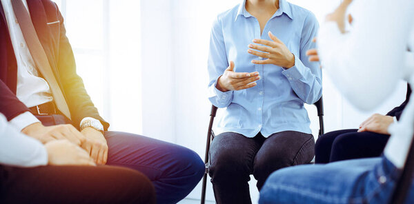 Группа людей, сидящих в кругу во время терапии в офисе. Встреча бизнес-команды, участвующей в тренинге