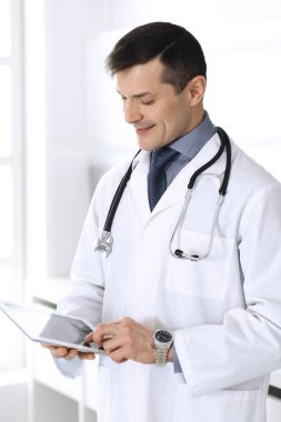 Doktor, ağ araştırması ya da sanal hastalık tedavisi için tablet bilgisayar kullanıyor. Klinikte mükemmel bir tıbbi hizmet. Modern tıp, tıbbi veriler ve sağlık hizmetleri kavramları için mutlu bir gelecek.