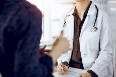 Doktor ve hasta güneşli klinikte otururken sağlık muayenesini tartışıyorlar. Tıp konsepti