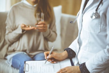 Bilinmeyen kadın doktor ve hasta içeride otururken sağlık muayenesini tartışıyorlar. Coronavirus salgını ve kendini izolasyon karantinası süresince evde kal