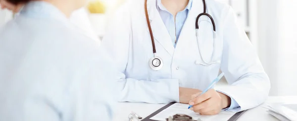 Mulher-médica desconhecida e paciente sentada à mesa. Muito boa notícia e conceito de serviço médico de alto nível — Fotografia de Stock