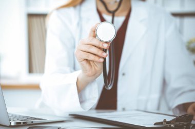 Elinde steteskop olan kimliği belirsiz bir kadın doktor. Doktor bir hastayı muayene etmeye hazır, yakın çekim. Tıp konsepti