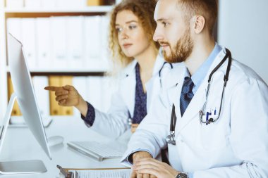 Kızıl sakallı doktor ve bayan meslektaşı güncel hastalık terapisini güneşli klinikte çalışırken tartışıyorlar. Tıpta takım çalışması