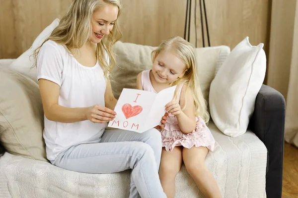 Happy mother day. Child daughter congratulates mom and gives her postcard with heart drawing. Family and childhood concepts — Stock Photo, Image