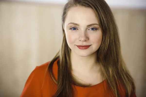 Kopfschuss einer smarten, selbstbewusst lächelnden Millennial-Europäerin, die mit verschränkten Armen zu Hause steht. Attraktive junge Teenager Studentinnen Freelancer Blick in die Kamera, gekleidet in rot — Stockfoto