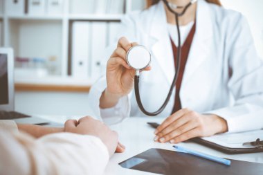 Elinde steteskop olan kimliği belirsiz bir kadın doktor. Doktor bir hastayı muayene etmeye hazır, yakın çekim. Tıp konsepti