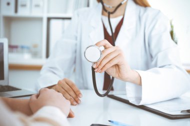 Elinde steteskop olan kimliği belirsiz bir kadın doktor. Doktor bir hastayı muayene etmeye hazır, yakın çekim. Tıp konsepti