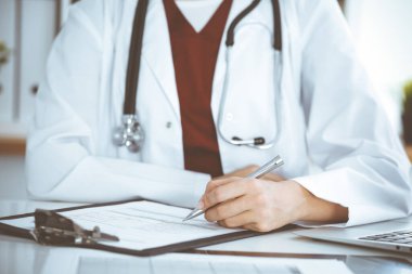 İş yerindeki başvuru formunu dolduran kimliği belirsiz kadın doktor. Tıp konsepti