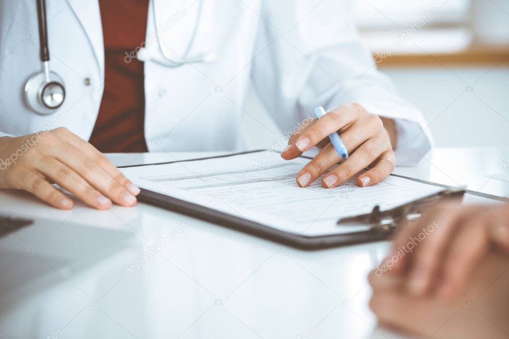 Unknown woman-doctor consulting patient and using clipboard with a medication history record. Medicine concept