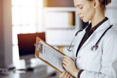 Güneşli klinikte pano kullanan kimliği belirsiz bir kadın doktor. Tıp konsepti