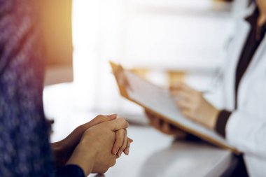 Doktor ve hasta güneşli klinikte otururken sağlık muayenesini tartışıyorlar. Tıp konsepti