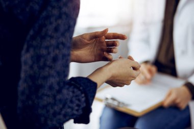 Doktor ve hasta güneşli klinikte otururken sağlık muayenesini tartışıyorlar. Tıp konsepti