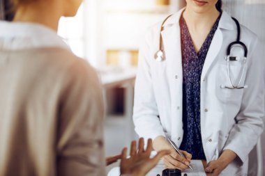 Doktor ve hasta güneşli klinikte otururken sağlık muayenesini tartışıyorlar. Tıp konsepti