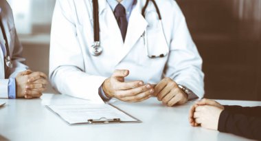 Meçhul erkek doktor modern klinikte otururken hasta kadını dinliyor. Mükemmel tıbbi servis, Coronavirus salgını sırasında ilaç konsepti. Covid 2019