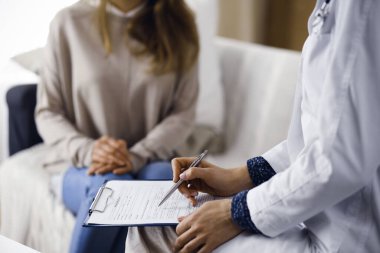 Bilinmeyen kadın doktor ve hasta içeride otururken sağlık muayenesini tartışıyorlar. Coronavirus salgını ve kendini izolasyon karantinası süresince evde kal