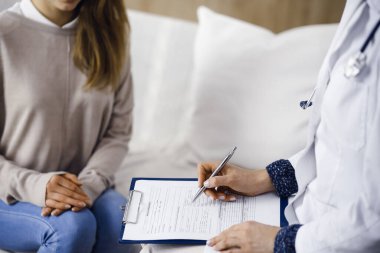 Bilinmeyen kadın doktor ve hasta içeride otururken sağlık muayenesini tartışıyorlar. Coronavirus salgını ve kendini izolasyon karantinası süresince evde kal