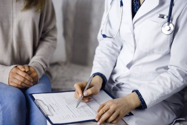 Bilinmeyen kadın doktor ve hasta içeride otururken sağlık muayenesini tartışıyorlar. Coronavirus salgını ve kendini izolasyon karantinası süresince evde kal