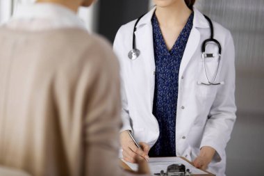 Doktor ve hasta klinikte otururken sağlık muayenesini tartışıyorlar. Hastanede mükemmel bir tıbbi hizmet. Tıp konsepti